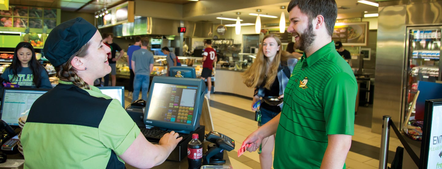 Student checking out at university dining center with UOID card.